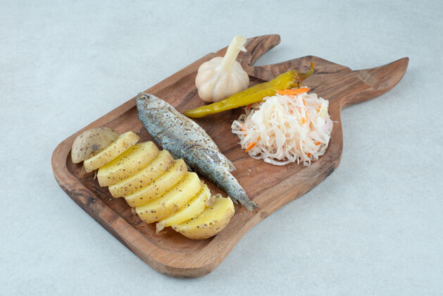 美味青鱼 煮土豆和泡菜放在木板上鱼胡椒土豆