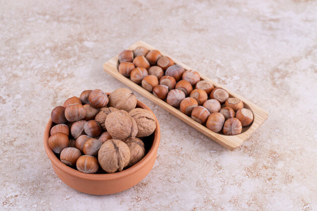 各种各种坚果放在大理石表面的木碗上健康好吃碗