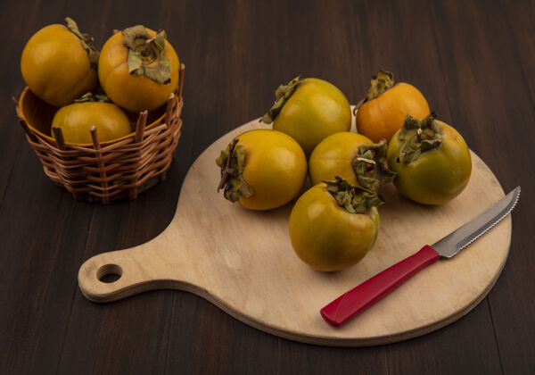 柿子新鲜的有机柿子水果的顶视图在一个木制的厨房板与刀在一个木制的桌子上水果新鲜厨房