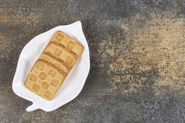 烤的叶子形状的盘子上放着方形的甜饼干饼干脆的小吃