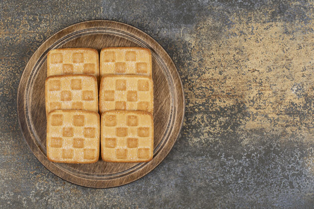 小吃方块饼干放在木板上点心烤的饼干