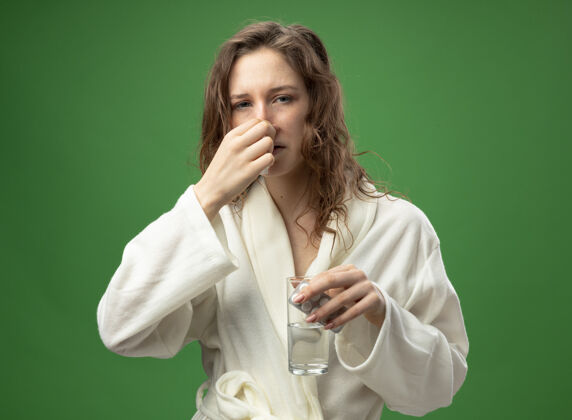 绿年幼体弱多病的女孩身穿白色长袍 手里拿着一杯药水 一把抓住绿鼻子鼻袍弱