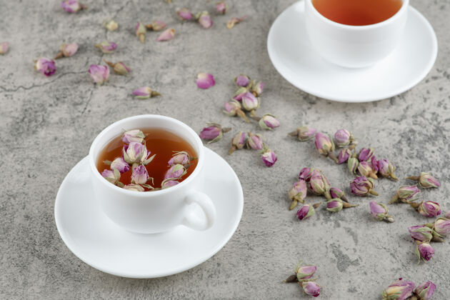 健康两杯红茶和大理石上的干花液体美味自然
