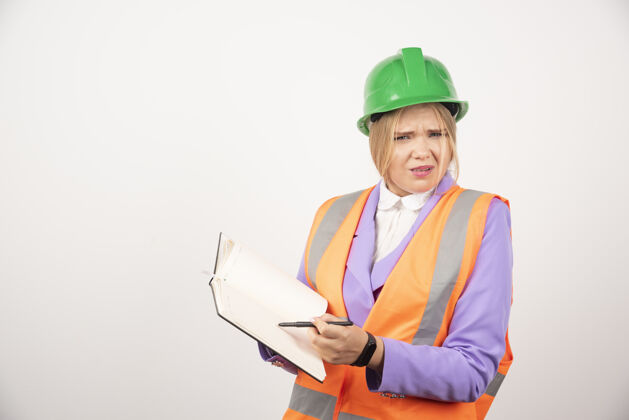 剪贴板女建筑工人戴着头盔 白色背景上有平板电脑高质量照片建筑人类建筑