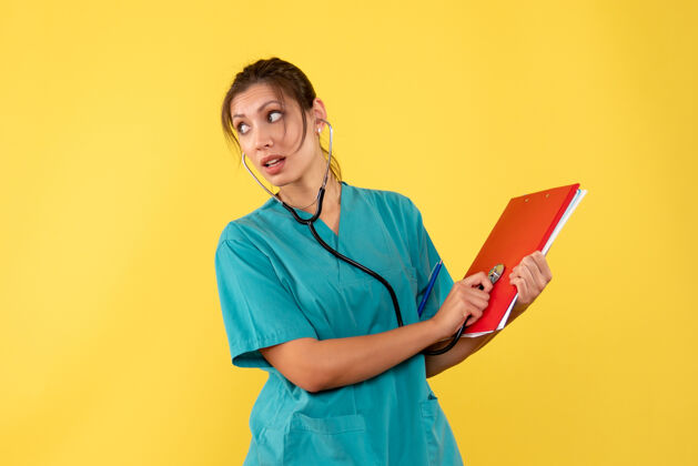 病毒前视图穿着医用衬衫的女医生 黄色背景上有听诊器和注释健康女医生笔记