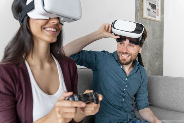 男人男人和女人坐在家里的沙发上 使用虚拟现实耳机娱乐家庭房子