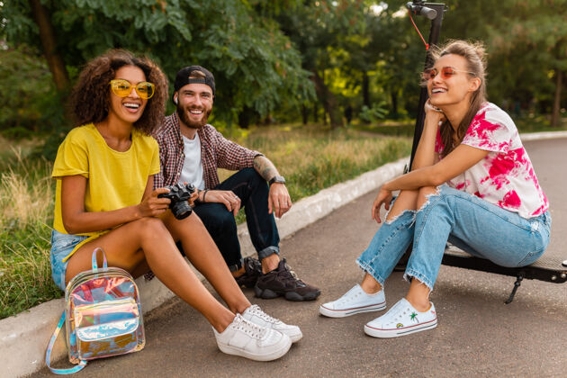 环保快乐的年轻朋友们坐在公园的草地上 带着电动脚踏车微笑着 男女同乐积极活动女士