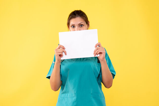 正面正面图黄色背景下穿着医疗衫的女医生拿着纸分析人物黄色纸张