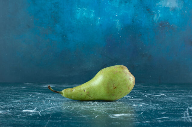 熟的大理石桌上有一个绿色的梨水果梨单一