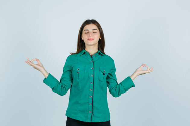 早晨身穿绿色衬衫 表情轻松的年轻女性 展现闭着眼睛的瑜伽姿势 正面视图瑜伽眼睛女人