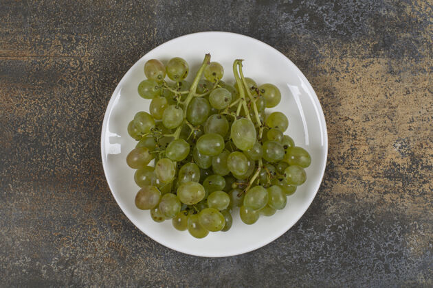 营养白盘子上一簇绿葡萄浆果葡萄明亮