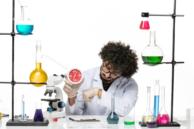 钟正面图穿着医疗服的男性化学家在空白处拿着时钟化学容器科学