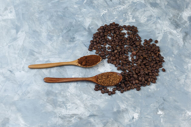 想法一套速溶咖啡和咖啡粉装在木制勺子里 咖啡豆放在浅蓝色大理石背景上顶视图咖啡拿铁女性