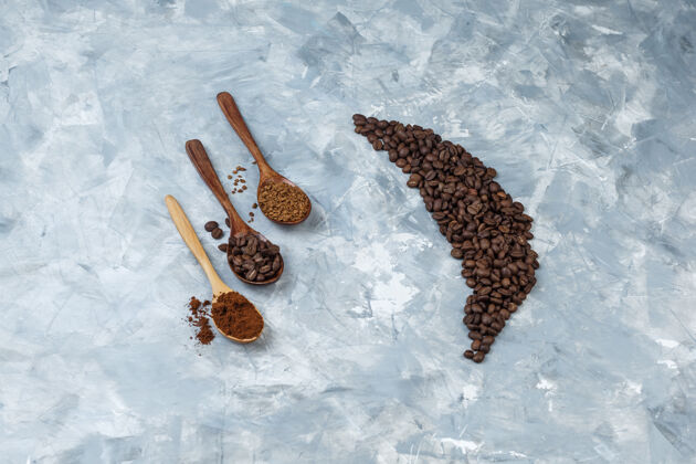 豆子高角度查看咖啡豆与咖啡豆 速溶咖啡 咖啡粉在浅蓝色大理石背景木制勺子水平艺术面粉角度