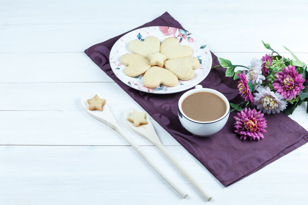 餐垫高角度观看心形饼干 一杯咖啡放在紫色的花垫上食物饼干美味