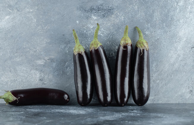 成熟新鲜的茄子排在灰色的背景上划船茄子晚餐