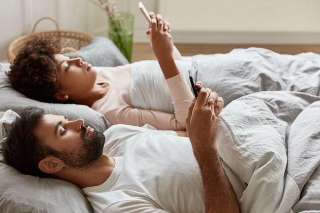 手机轻松严肃的情侣分享电话里的照片手表卧室阅读
