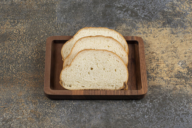 一餐美味的白面包片放在木盘上自然面包小麦
