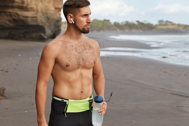 未刮胡子运动型男性的短镜头有肌肉的身体休息和喝淡水作物动机口渴