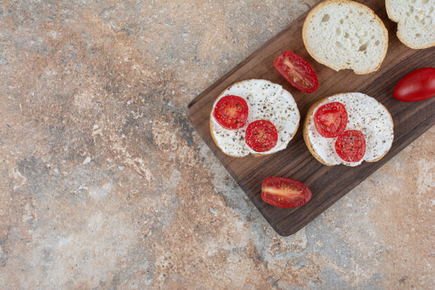 新鲜面包片加奶油和番茄放在木板上奶油番茄面包