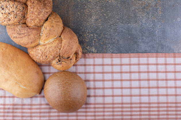 面包各式各样的面包放在大理石表面的桌布上各种面团各种