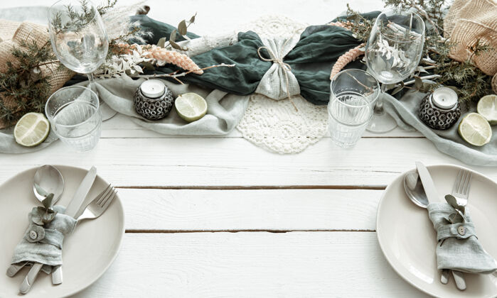 盘子时尚的节日餐桌设置 木质表面有斯堪的纳维亚装饰细节灯室内明亮
