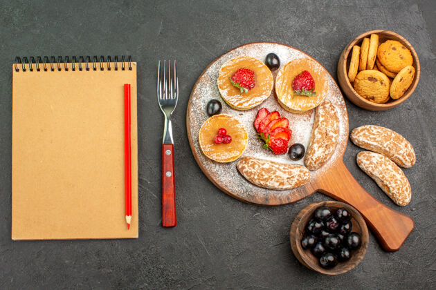午餐俯瞰美味的薄煎饼与水果和甜饼在黑暗的表面蛋糕甜点晚餐食物早餐