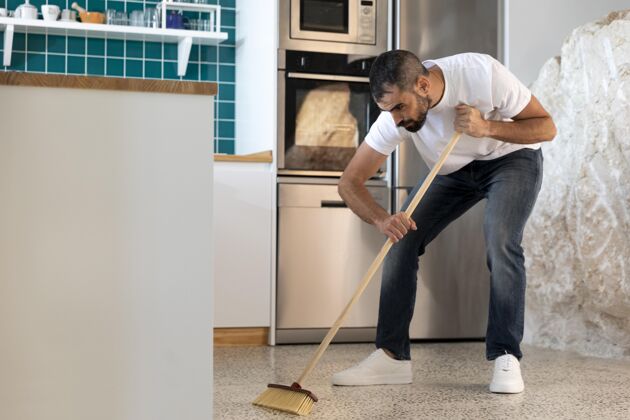 厨房全明星男人在打扫厨房扫帚清洁生活方式