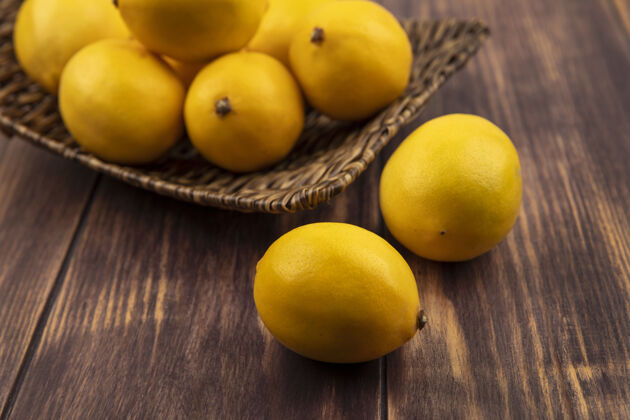 木材柳条托盘上健康柠檬的俯视图 柠檬被隔离在木墙上柳条柑橘块