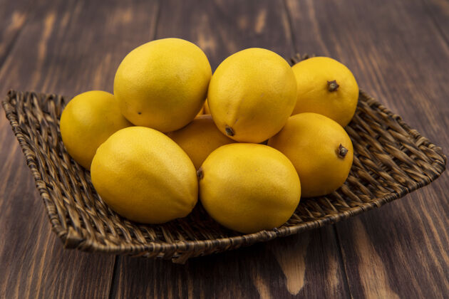 水果木墙上柳条托盘上新鲜黄色柠檬的俯视图切片景观新鲜
