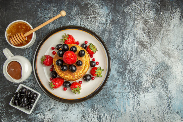 食物俯瞰美味的薄饼配蜂蜜和水果 表面水果蛋糕清淡甜美营养餐碗