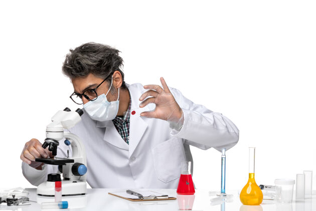 化学前视图穿着白色医疗服的中年科学家正在检查小样本人科学小