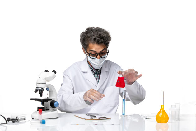 外套正面图中年科学家穿着特制的衣服坐着拿着装有溶液的烧瓶实验室化学临床