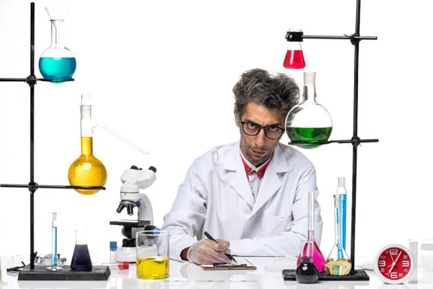 实验正面图身着白色医疗服的中年化学家在写笔记化学实验室外套研究