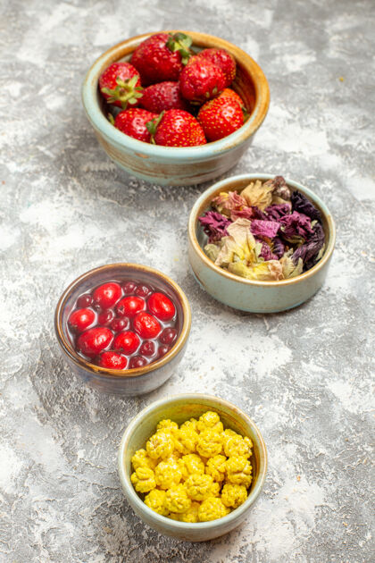 新鲜正面图新鲜的红色草莓和糖果在白色表面浆果糖果水果食物膳食浆果