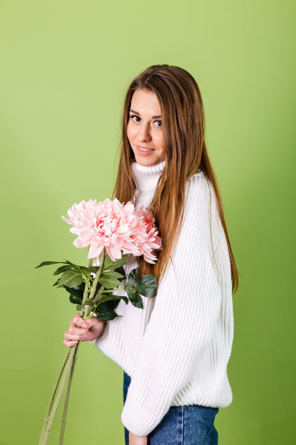 开花漂亮的欧洲女人穿着休闲的白色毛衣孤立 浪漫的样子拿着一束粉红色的花微笑着菊花深色自然