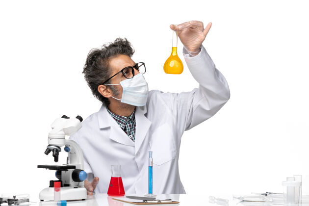 溶液正面图身着特殊套装的中年科学家拿着装有溶液的烧瓶外套科学实验室外套