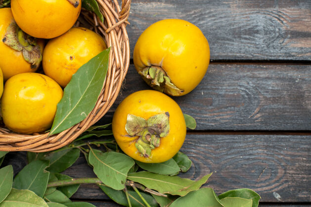 柑橘顶视图新鲜柿子在木地板上的篮子里果实醇厚成熟木头顶部健康