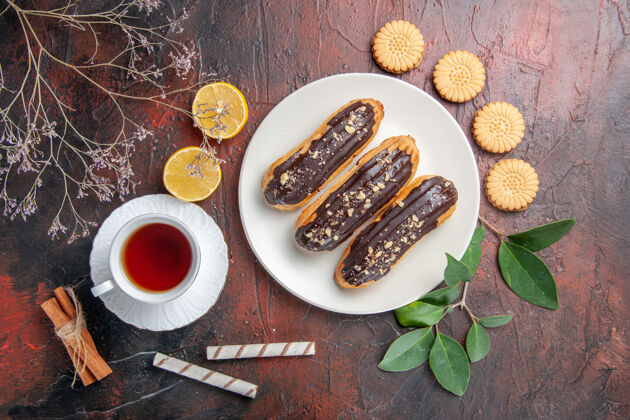 肉顶视图一杯茶 配上饼干和黑桌子上的冰糕糖茶饼干糖饼干餐Eclair