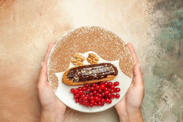 蛋糕顶视图美味的eclair 带红色浆果 放在浅色桌上 甜点蛋糕食物石榴浆果