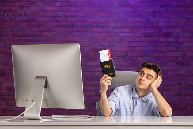 前台正面图：上班族拿着护照和机票坐在工作地点后面工作度假紫色