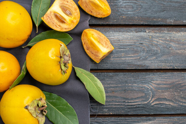 柿子顶视图新鲜甜甜的柿子放在木质质朴的餐桌上 醇香果香健康有机黄色柑橘