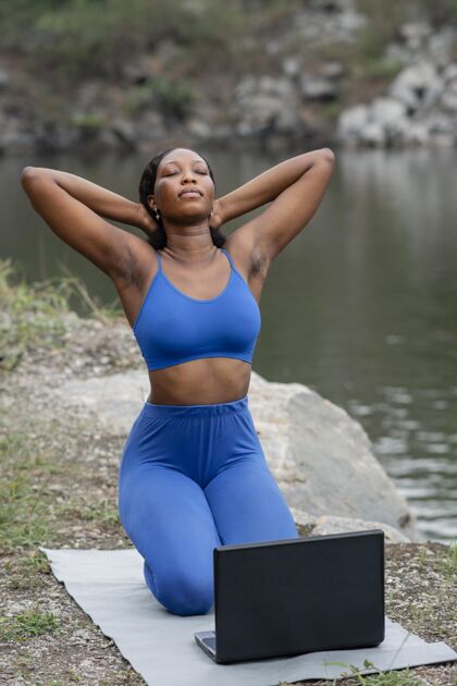 柔韧教学生瑜伽姿势的女人健康笔记本电脑放松