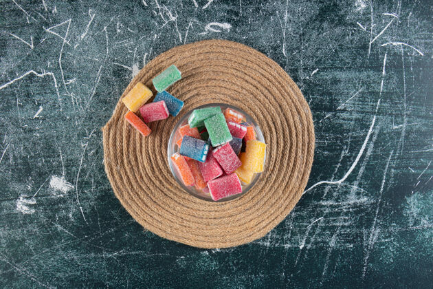 活力一碗五颜六色的糖果放在三角架上 放在混合桌上多彩糖美味