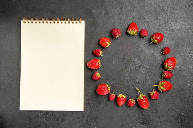 新鲜的红色草莓顶视图新鲜的红色草莓衬在一个深灰色的表颜色浆果记事本顶部浆果