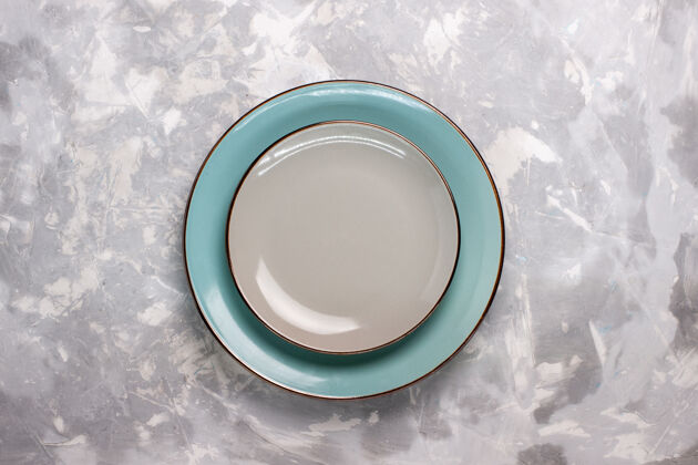 液体白色表面上由玻璃制成的空盘子的俯视图盘子容器餐具