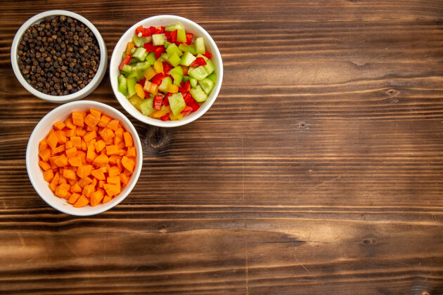 食物顶视图棕色木桌上不同调味料的甜椒切片蔬菜餐食品健康沙拉餐桌水果健康