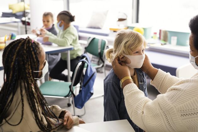 学术女老师帮孩子们戴医用口罩老师孩子社区