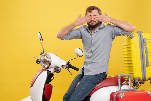 人旅游概念与年轻的胡须男子坐在摩托车上 闭上眼睛看它的黄色汽车摩托车汽车