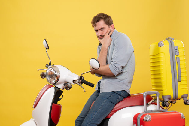车旅游概念与年轻的胡须男子坐在摩托车上 在它的思想深刻的黄色摩托车传送带人